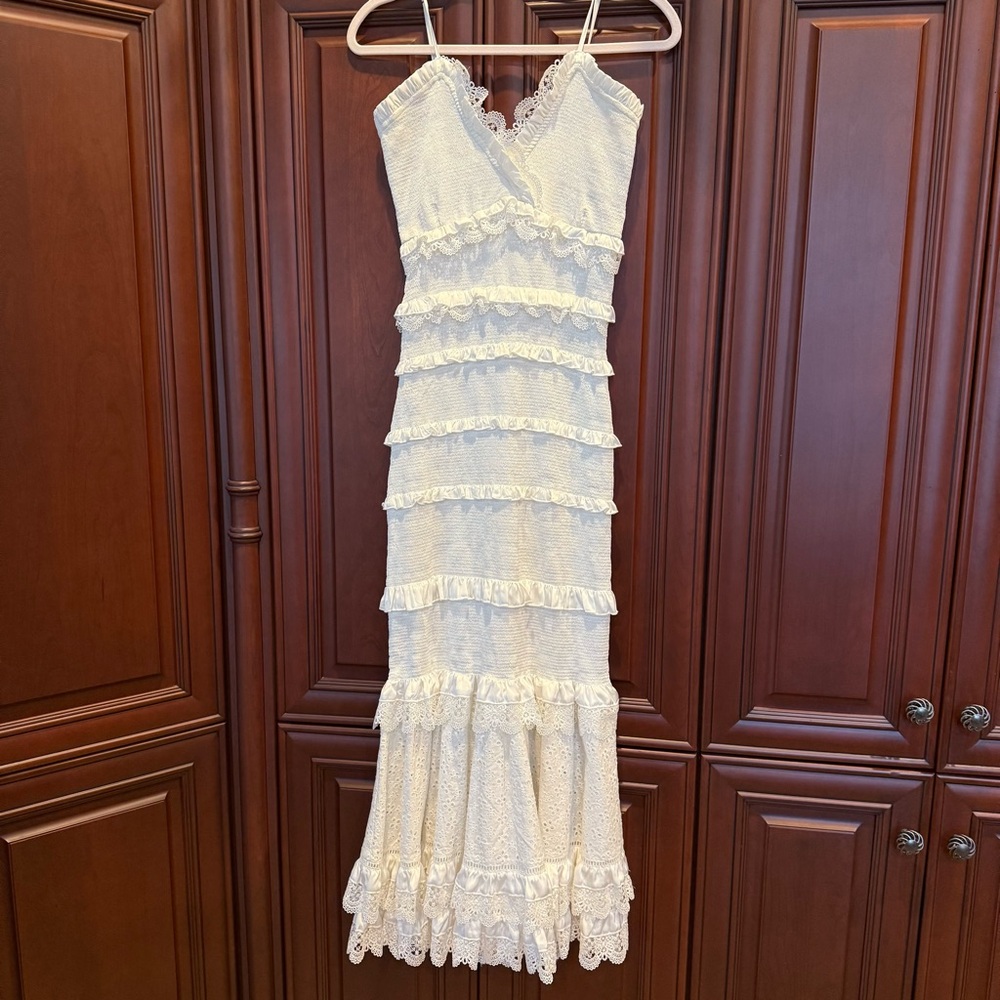 V Chapman white Narcisse dress with eyelet detail on bottom.
